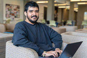 Aldo Cisneros types on his laptop in Gray Wolf Hall