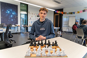 EvCC student and MESA Ambassador Georgiy Lapin sits in front of a chess board.