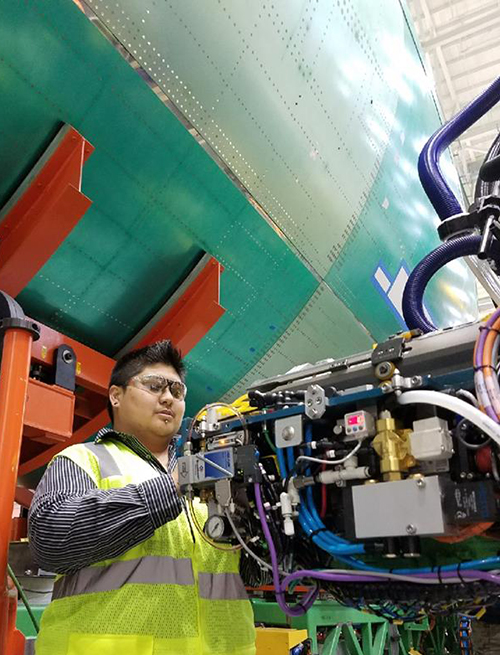 Jaxon Kronberger inspects robotic tooling at Boeing. Courtesy of Boeing.