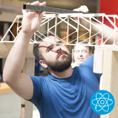A student works with a bridge model, with an icon of an atom in the corner.