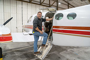 EvCC Aviation Maintenance Technician student Shad Fleshman-Cooper on stairs entering aircraft. 