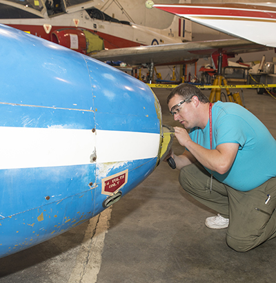 An avionics student inspects an aircraft nosecone.