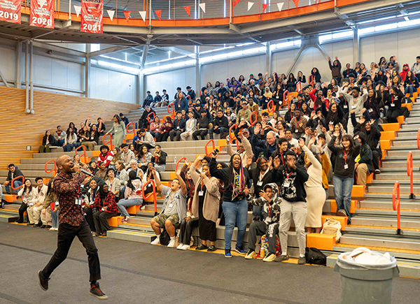 Students of Color Career Conference MC Dennis Denman energizes the crowd during the opening ceremony March 21.