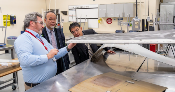 At EvCC’s Advanced Manufacturing Training & Education Center, (from left) EvCC aerospace composite technology instructor Michael Patching explains the construction of an airplane wing created with composite materials with JFOU President Hiroaki Hatayama and Mr. Takeru Terasaw from the office of the JFOU President.