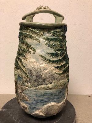 Ann Morgan- ceramic vase with a natural scene on the side.