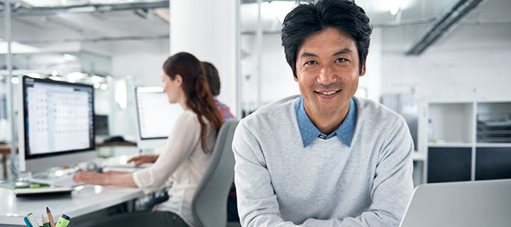 man on laptop in office environment